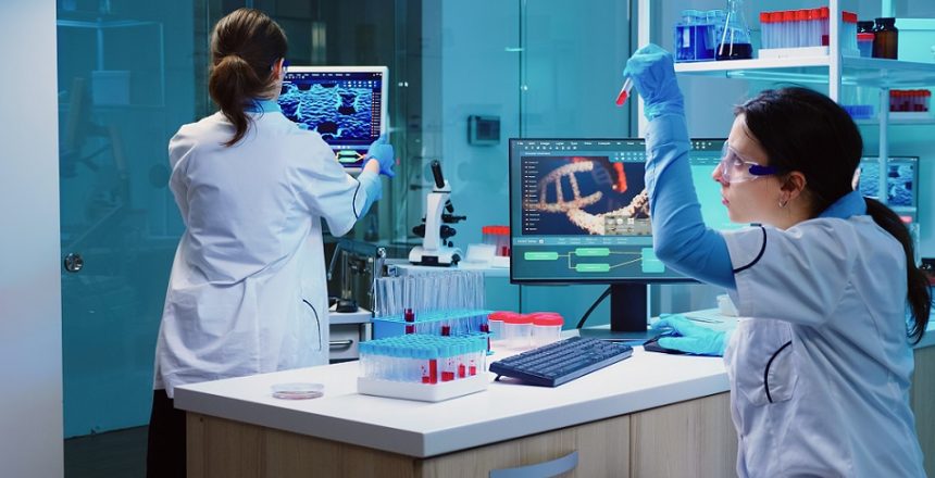 Group of scientists wearing lab coat working in laboratory while examining biochemistry sample in test tube and scientific instruments. Science technology research and development study concept.