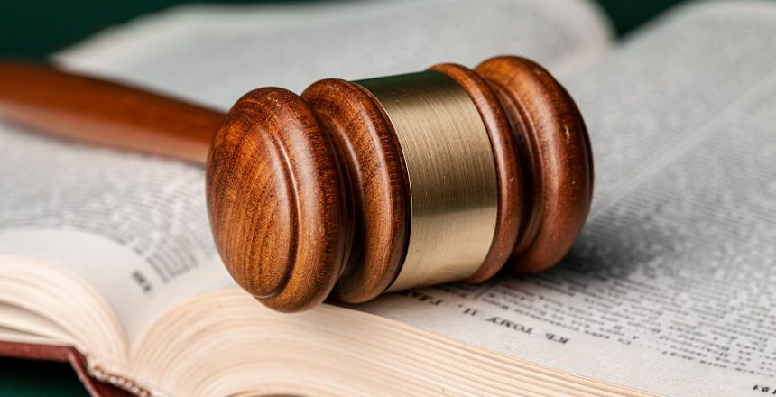 Close up of a brown wooden gavel and book