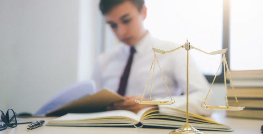 Young lawyer business man working with paperwork on his desk in office.