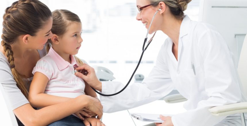 Mother with girl being examined by female doctor in clinic